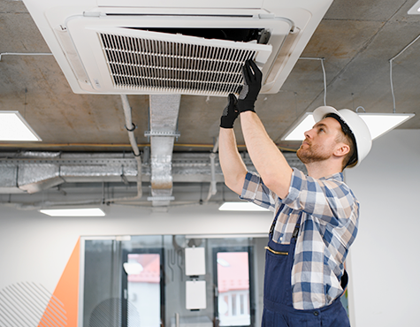 Person installing ceiling air conditioner