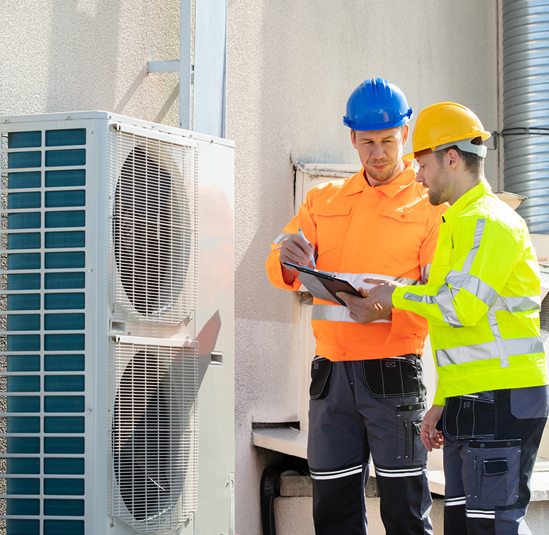 Workers inspecting air conditioning unit