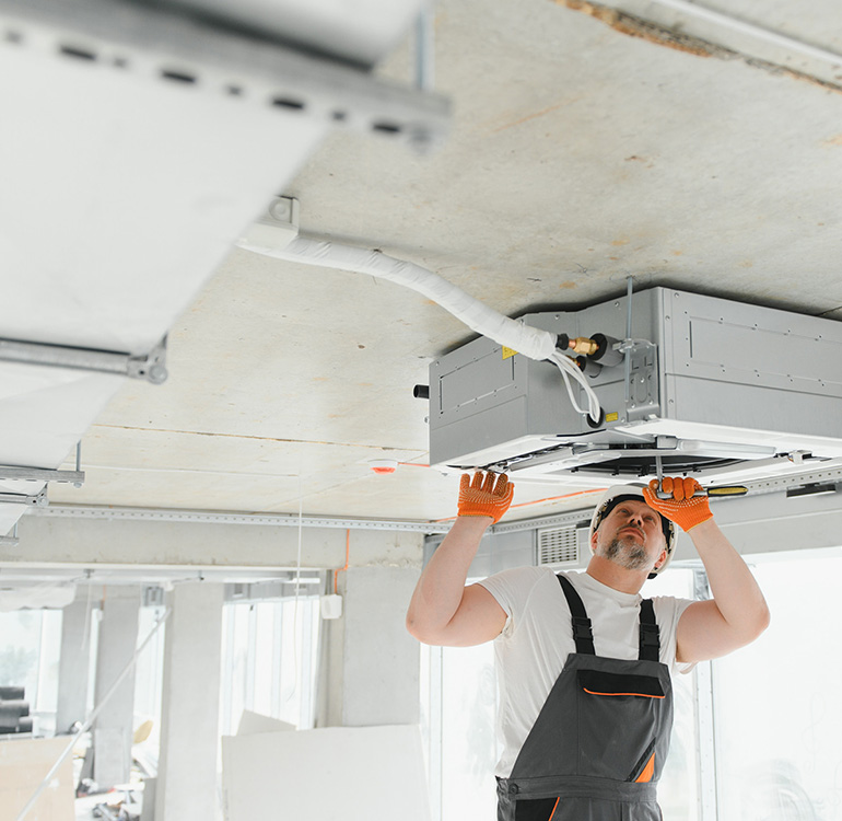 Person installing ceiling air conditioning