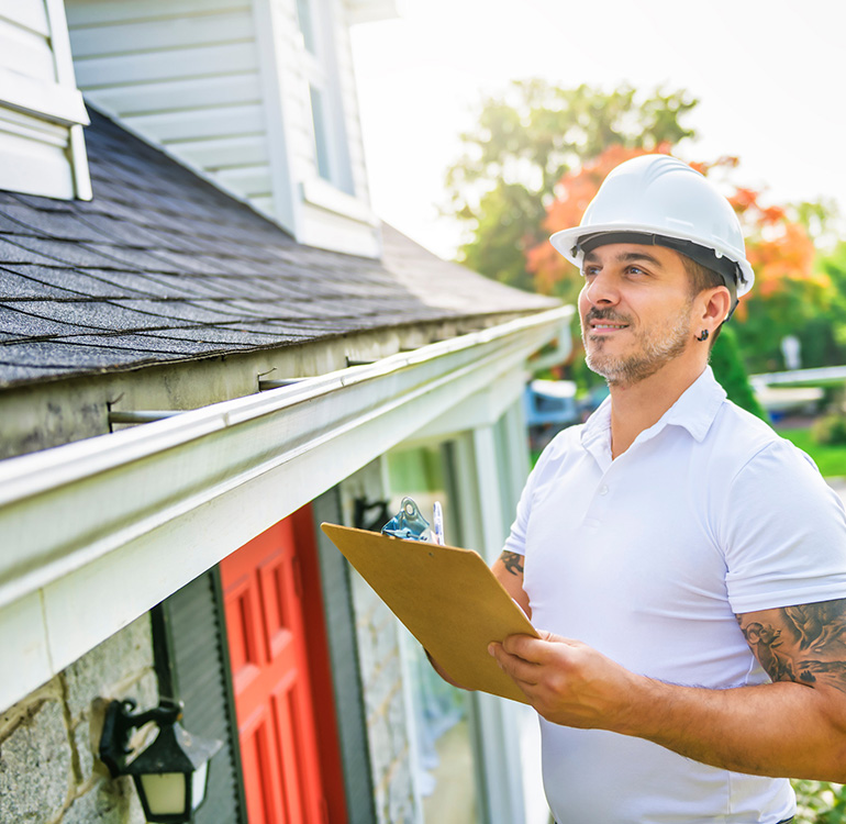Home inspector examining house roof