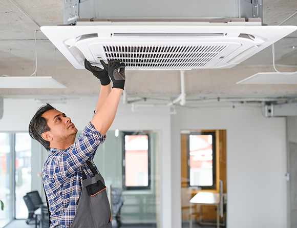 Person installing ceiling air conditioner